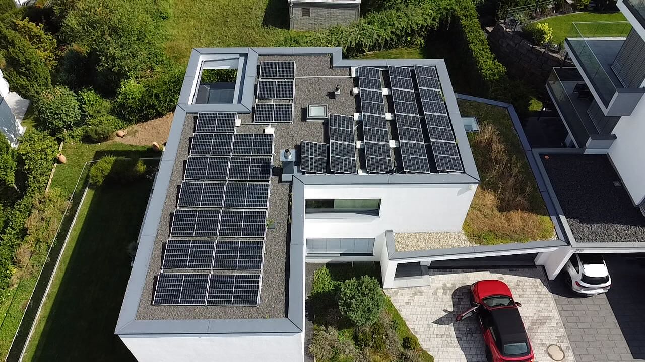 Luftbild eines Vimasol Projekts: Photovoltaikmodule auf dem Flachdach eines modernen Wohnhauses